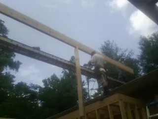Carpenter setting a ridge beam over a new addition frame — Ice Dam Removal by Roofing Brothers in Whitefield