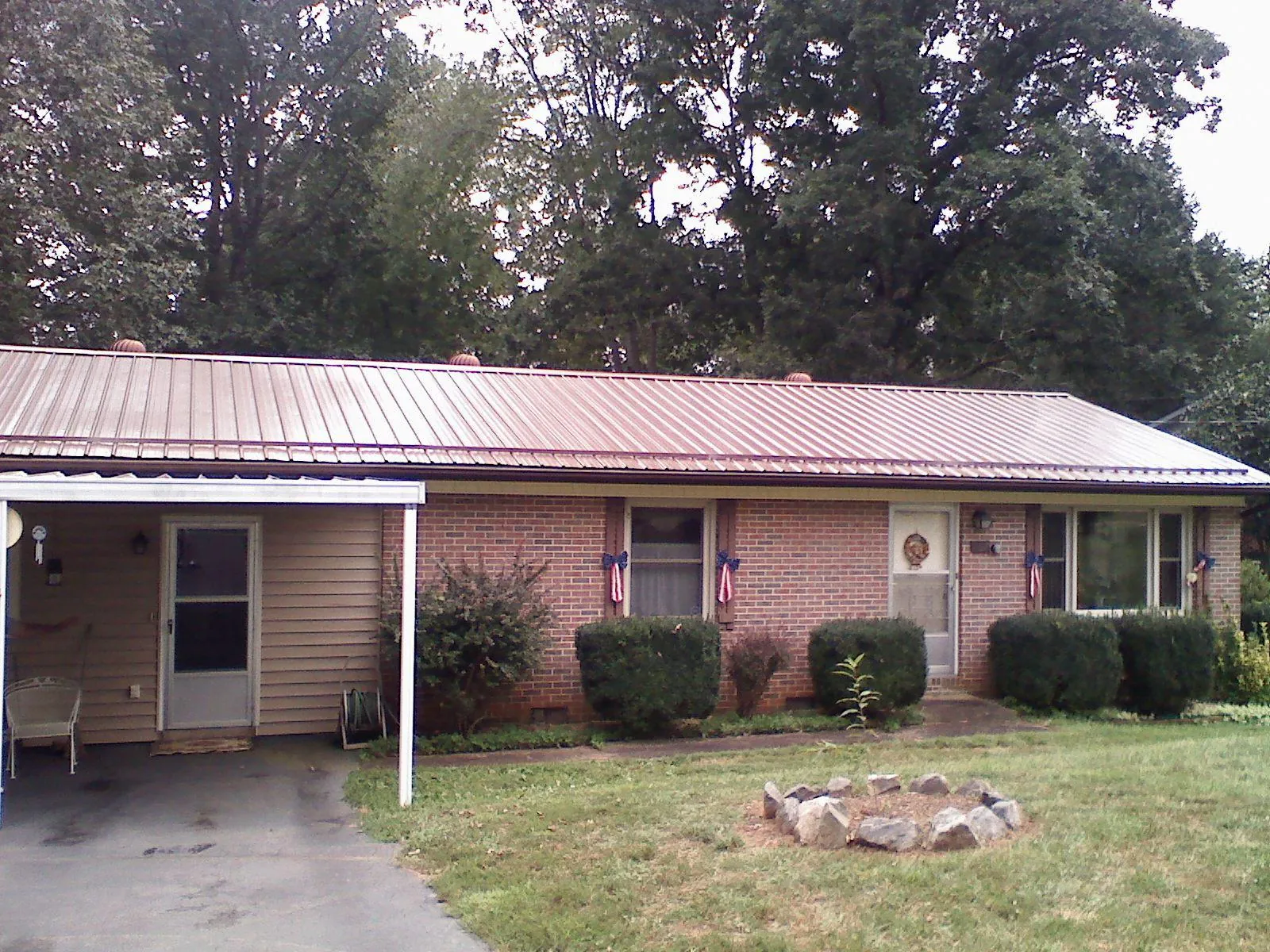 Bronze metal roof and carport on a brick ranch home — Roof Repair work by our crew in Whitefield